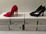 two pairs of red and black high heels sitting on top of boxes