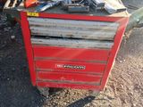 une boîte à outils rouge sur laquelle sont posés des outils