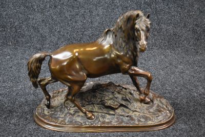 bronze statue of a horse running on a rock on a black background