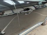 a reflection of a man in the door of a car