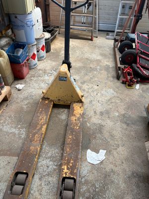 un chariot élévateur garé dans un garage rempli d'outils