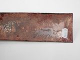 an image of a piece of rusted metal on a white surface
