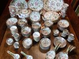 many plates and bowls on the table with spoons and spoons