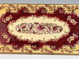 un gros plan d'une assiette rouge et dorée ornée d'un motif floral