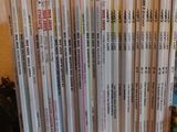 beaucoup de livres posés sur une table à côté d'une plante en pot