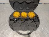 three yellow sunflowers in a black case on a table