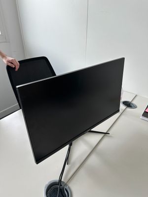 une personne debout à côté d'un téléviseur à écran plat posé sur un meuble