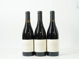 trois bouteilles de vin posées sur une table blanche