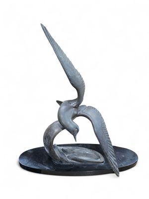 a statue of two birds on a plate with a white background