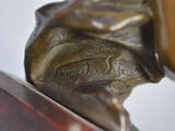 a bronze statue of a man holding a baseball bat