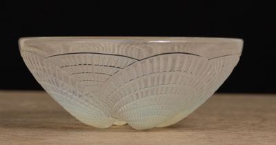 un saladier en verre posé sur une table, sur fond noir