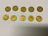 a bunch of gold coins sitting on top of a white table