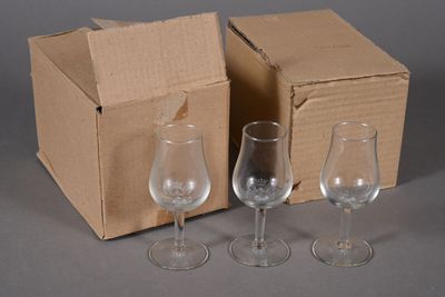 trois verres à vin vides devant une boîte en carton