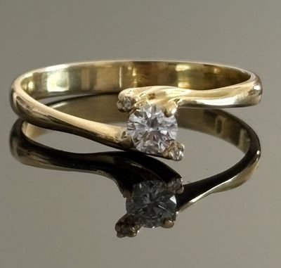 a gold ring with a diamond on top of it