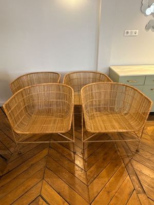 trois chaises en osier et une table dans une pièce au sol en parquet
