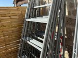 a ladder leaning up against a wall next to a wooden fence