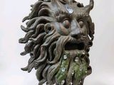 a statue of a man with a beard and a green face