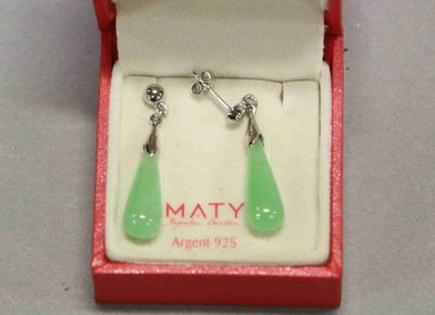 une paire de boucles d'oreilles dans une boîte rouge posée sur une table