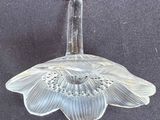 a glass vase with a flower on it on a table
