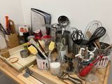 many utensils and other kitchen utensils on a wooden table
