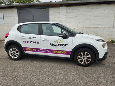 une petite voiture blanche garée devant un bâtiment