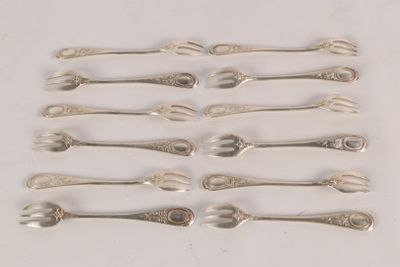 six silver spoons and two silver spoons on a white surface