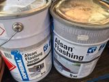 two buckets of paint sitting on top of a table