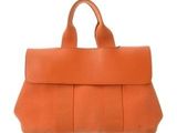 an orange leather handbag on a white background