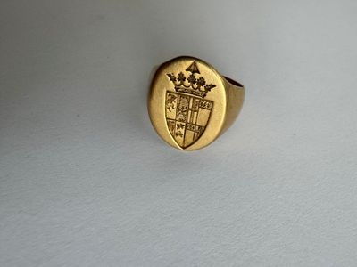 an image of a gold ring with a crest and crown on it