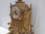 a gold clock with a crown on top of it