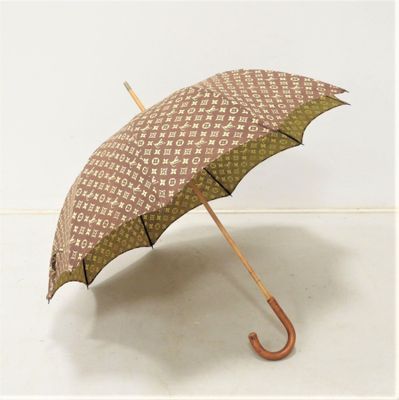 un parapluie marron et blanc avec un manche en bois