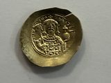an old gold coin sitting on top of a white surface