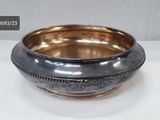 silver plated bowl with beaded rim on a white surface