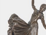 an image of a bronze statue of a woman in a long dress