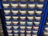 a blue rack filled with lots of plastic bins filled with assorted items