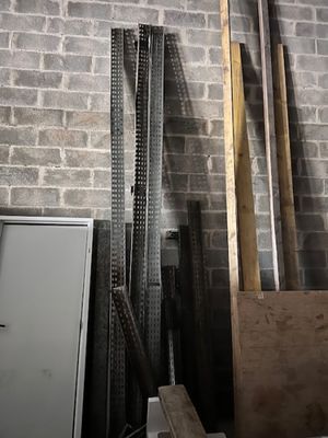 plusieurs morceaux de bois sont empilés contre un mur de briques