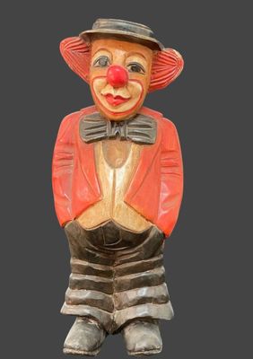 une statue en bois représentant un clown portant un chapeau et une cravate