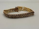 a close up of a gold chain bracelet on a white surface