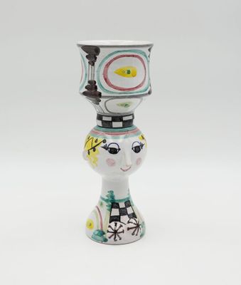 a small vase that has a face on top of it