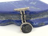 an image of a close up of a black and white diamond ring on a blue stone
