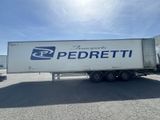 Le semi-remorque est garé sur le parking à côté du bâtiment.