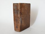 an old book that is sitting on a white surface