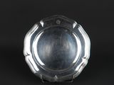 a silver plate on a black background with a black background