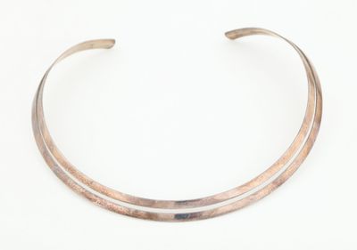 gros plan d'un bracelet en argent sur une surface blanche