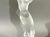 a glass sculpture of a woman standing on a base