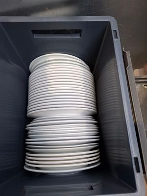a stack of white plates in a plastic container