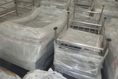 de nombreux lits dans une chambre, emballés dans du plastique