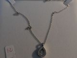 silver plated necklace with a tear shaped pendant and a cross on a chain