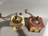 two old coffee grinders sitting next to each other on a table