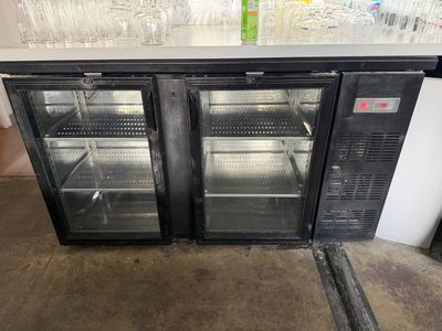 two glass door refrigerators that are sitting on the floor
